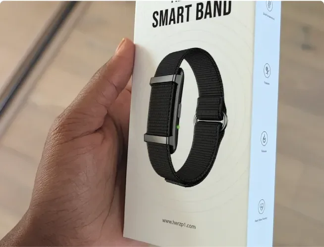 Herz P1 Smart Band retail box held in a hand showing the band and herzp1.com website
